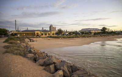 Beautiful golden hour view of Geraldton City Beach foreshore featuring the prominent yellow Dome cafe with solar panels on the roof, a…