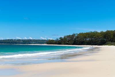 People enjoying the sunny weather on the beach in Jervis Bay Marine Park, city of Huskisson, NSW, Australia