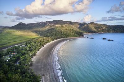 Aerial drone image at sunrise over Cape Hillsborough with blue water and green rainforest and nice morning warm sunlight