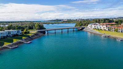 Aerial view of Hastings River and riverside Port Macquarie town in Australia under blue cloudy sky