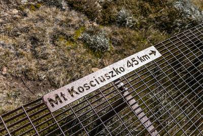Close-up of public signage on the rusty steel boardwalk connecting the summit of Mount Kosciuszko (2228m above sea level) with Thredbo…