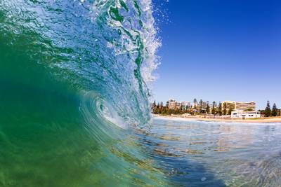 Idyllic view of North Wollongong Beach on the Illawarra Coast captured from within the ocean as a crystal clear turquoise shorebreak…